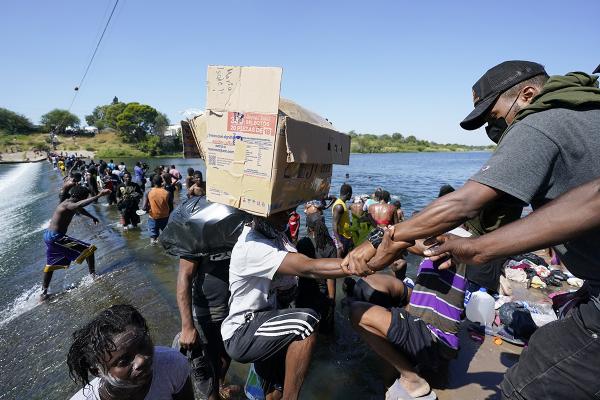 Immigrants, many from Haiti, cross a dam to get into the U.S. at Del Rio Texas. 