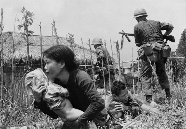 woman tries to carry a child to safety as U.S. Marines storm the village of My Son, S Vietnam