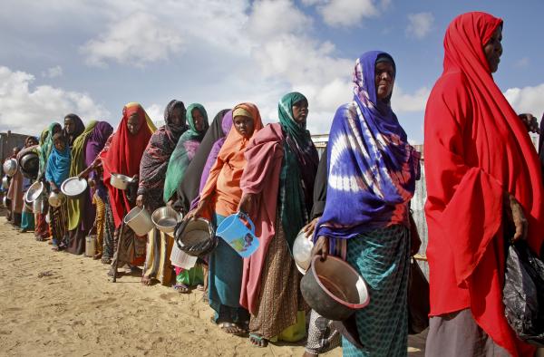 Somalian women flee drought-caused famine and queue for food handouts.