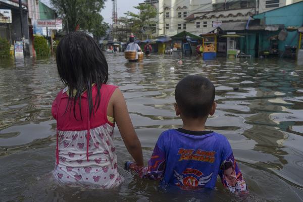 Indonesia: two children waist-deep in flood water caused by heavy rains.