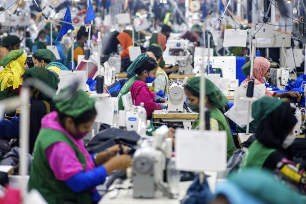 People crowded together sewing garments in factory in Bangladesh.