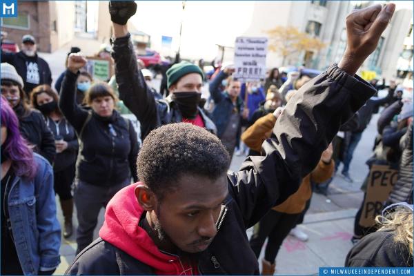 Milwaukee protesters raise fists against Rittenhouse verdict.