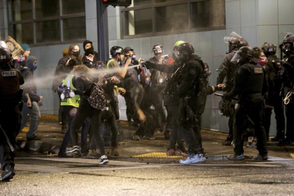 Portland police spray pepperspray directly on protesters.
