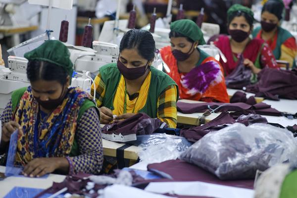 Women run sewing machines in clothing factory in Bangladesh during Covid surge.