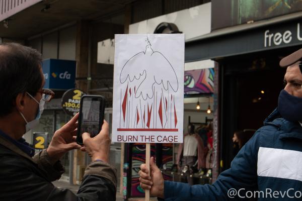 Protest sign "Burn the Cage" in Bogotá for Iranian political prisoners.
