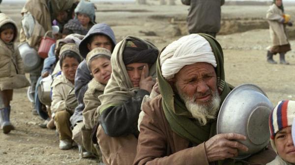 Starving Afghanistan people of all ages wait in line for food portion.