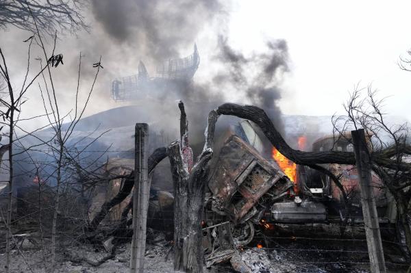 Damage from Russian missile strike on Ukraine, burning vehicle, smoke.