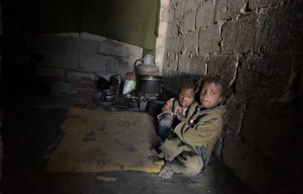 Two Yemen refugee boys huddle in a dark cave