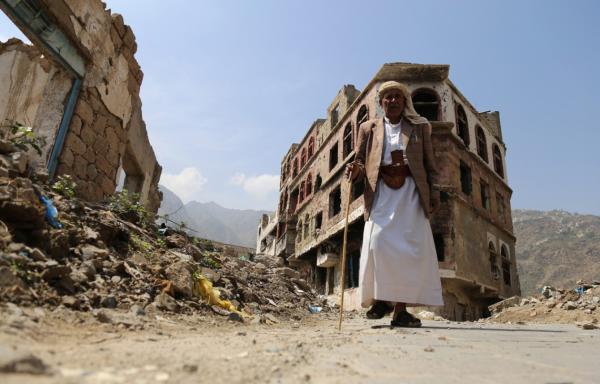 Eldery man stands in front of his home destroyed by Saudi Arabia airstrikes in Yemen.