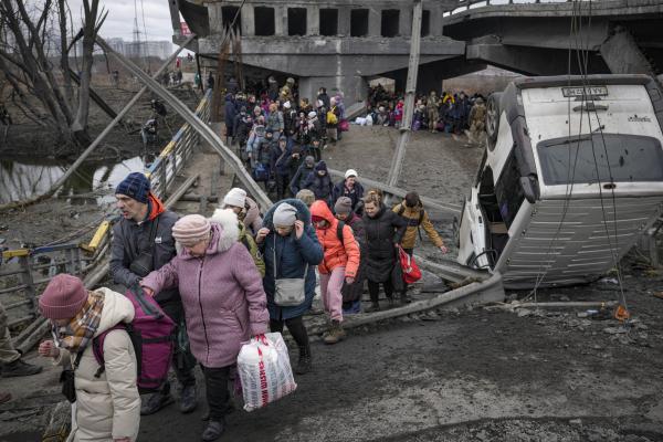 Ukrainians walk path after Russian airstrike destroyed bridge.