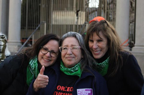 Three speakers Sunsara Taylor, Ariceli Herrera and Merle Hoffman hug after rally in New York City on IWD.