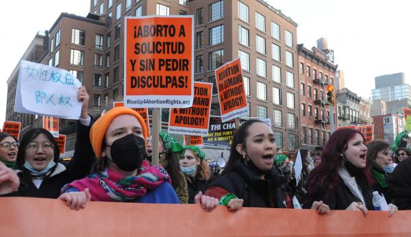 Women hold banner leading New York City International Women's Day march.