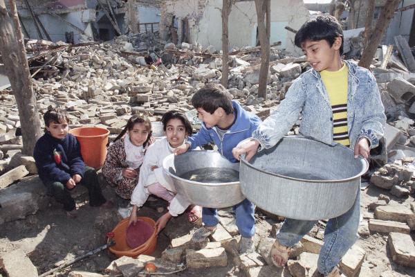 Children collect water, a scarcity after weeks of U.S. bombing of Baghdad.