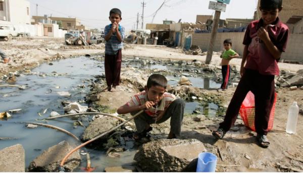 An Iraqi boy drinks water from a broken pipe in Baghdad's Sadr City, Iraq.