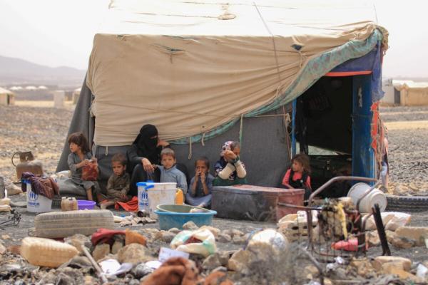 An internally displaced Yemeni family sit outside their shelter at Al-Suwaidan camp in Marib city, Yemen, June 2021. 