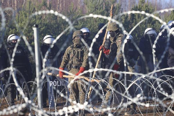 Police and barbed wire greet refugees from Middle East at Poland-Belarus border.