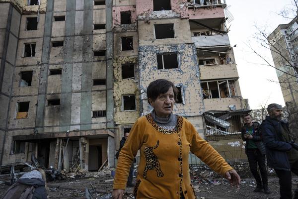 Woman walks away from destroyed building in Kyiv, Ukraine.