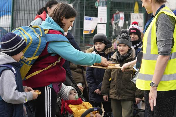 Ukrainian refugees being served refreshments upon their arrival in Poland.
