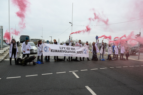Scientist Rebellion activists block a main highway in Berlin, Germany with red smoking flares.