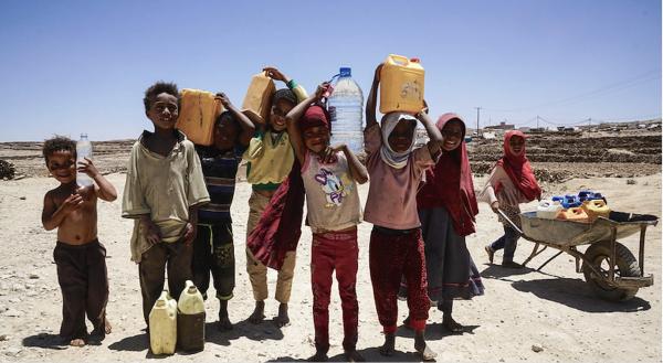 Children with gallon containers wait for water in Yemen.