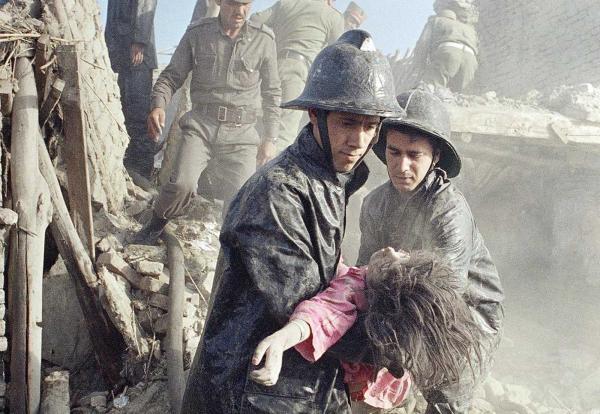 Afghan firefighters carry the body of a young girl killed in Kabul, 1988