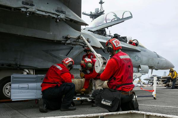 Sailors load bombs on aircraft carrier USS Abraham Lincoln. 