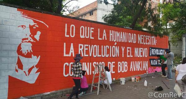 Bogota, Colombia, people paint a wall mural advertising Bob Avakian, New Communism.