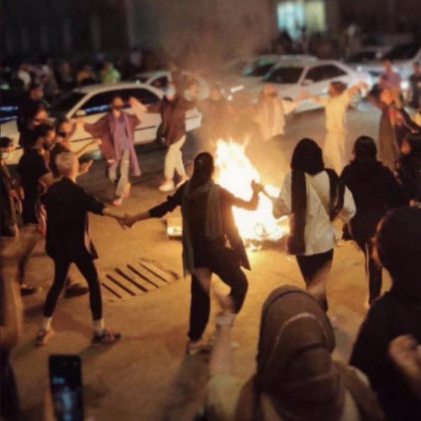 Iranian women without hijabs dance around a bonfire. 