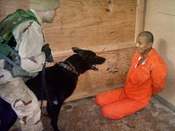Prisoner tortured with a dog at Abu Ghraib, Iraq, May 21, 2003.