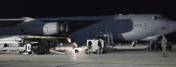 Night scene of a USAF bomber being loaded with nuclear air launched cruise missiles for Ukraine.