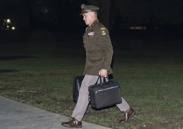 A U.S. Army officer military aide follows President Biden carrying the nuclear launch codes known as the "football."