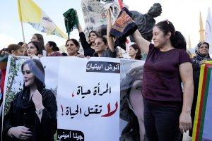 Kurdish women hold headscarfs high to protest murder of Mahsa Amini.