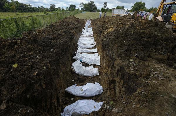A forensics team buries 15 unidentified migrants who died trying to cross the Darién Gap.