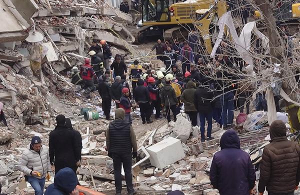 Turkish civilians work with rescue workers to search for survivors under the rubble of a collapsed building in southeastern Turkey, February 6, 2023.