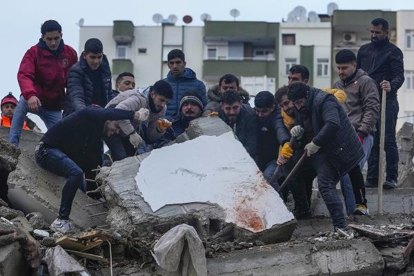 Turkey, February 6, 2023: people work together to lift heavy concrete slab in search for survivors of earthquake.