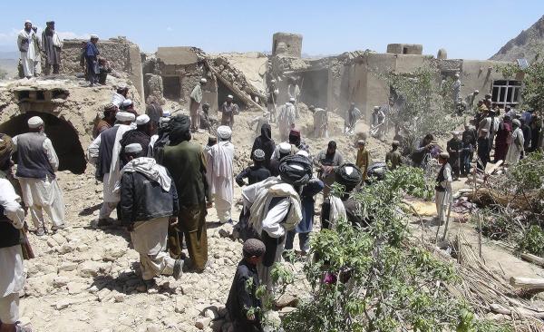 Villagers come through rubble from NATO airstrike on home in village near Kandahar, June 2012, that killed 18 civilians.