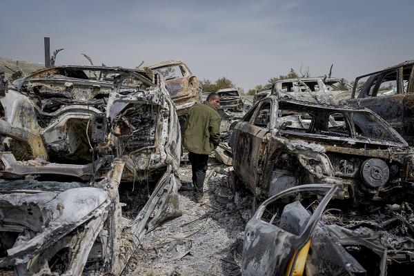 Palestine, February 27, 2023, a Palestinian man walks between scorched cars in a scrapyard, in the town of Huwwara.