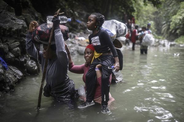 Haitian migrants wade through water as they cross the treacherous Darien Gap from Colombia to Panama.