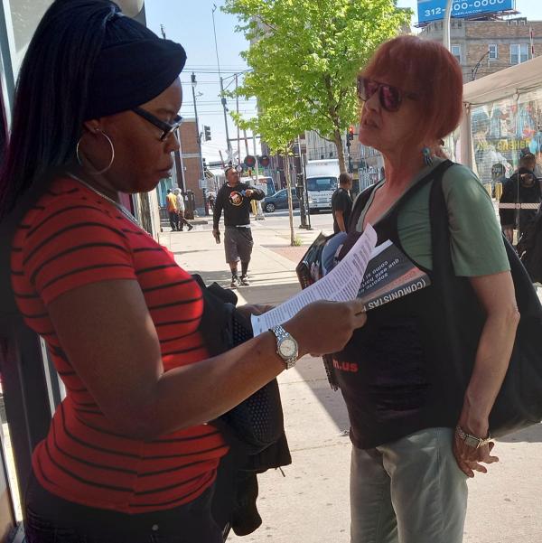 Chicago Revolution Club member distributes We Are the Revcoms to a woman.