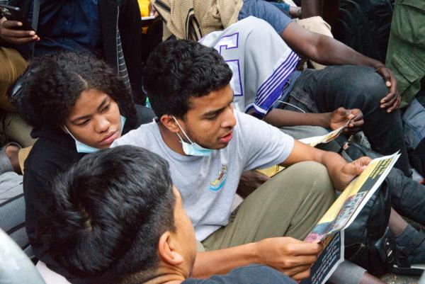 Migrants at Roosevelt Hotel, NYC, read the proclamation, We Are the Revcoms, August 1, 2023.