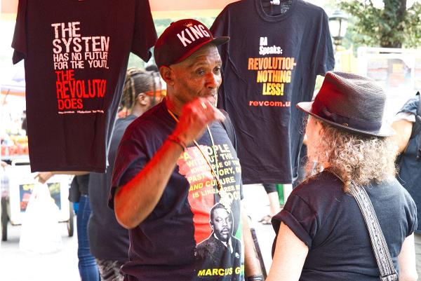New York City, Caribbean Day Parade, talkin to man at Revolution Books tent