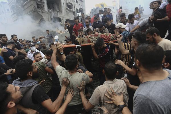 Palestinians remove bodies from bombed refugee camp at Jebaliya, October 9, 2023.