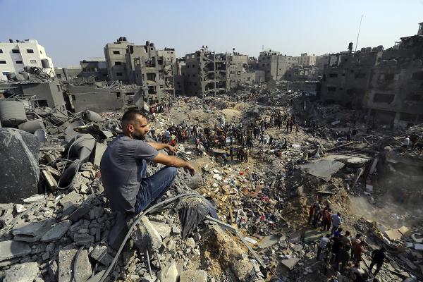 A man sits on the rubble as Palestinias search rubble in Jabaliya refugee camp, northern Gaza Strip, after Israeli airstrike, November 1, 2023.