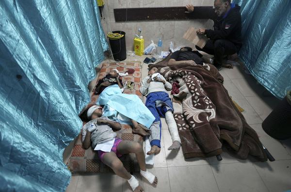 Palestinians wounded by Israeli bombardment of the Gaza Strip lie on floor in a makeshift treatment room at al Aqsa Hospital, Gaza Strip, November 23, 2023.