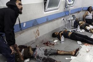 Wounded Palestinians lie on the floor in al-Shifa hospital in Gaza City