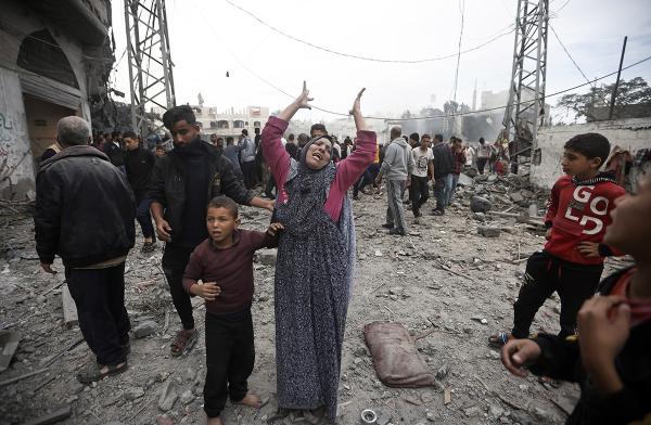 A Palestinian woman gestures after Israeli airstrikes in Khan Younis refugee camp, December 7, 2023.