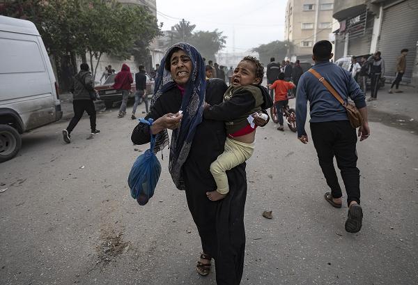 Palestinian mother and child and others evacuate safe zone Rafah, Gaza, after Israeli strike, December 20, 2023. 