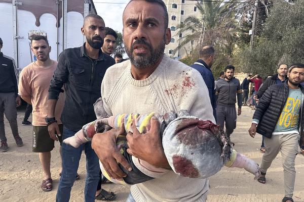 Palestinian rescues a child wounded by an Israeli strike on central Gaza Strip, December 28, 2023.