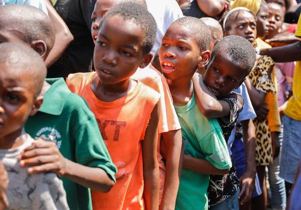Children line up to receive a plate of food at a shelter for families displaced by gang violence in Port-au-Prince, Haiti, March 14, 2024.