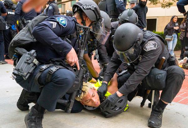 California:  At UC Irvine, cops restrain a pro-Palestinian protester as they began to raid encampment, May 15, 2024.
